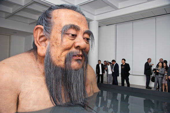 Visitors to the Rockbund Art Museum in Shanghai, China, react to a sculpture of Confucius by artist Zhang Huan.